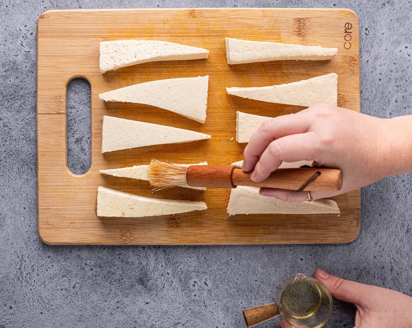 step 4 Once most of the liquid is drained from your tofu, cut it into thin strips. You can now choose to either cube the tofu or cut it into triangles as pictured. Coat your tofu pieces in Olive Oil (1 Tbsp), then sprinkle Corn Starch (1 tsp) on both sides.