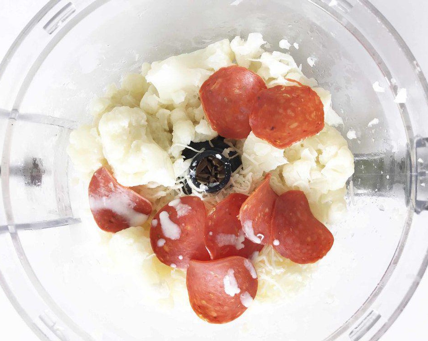 step 2 Once done, remove the cauliflower with a slotted spoon and transfer into a blender or food processor with Shredded Italian Blend Cheese (4 Tbsp), Turkey Pepperoni (8 slices), Heavy Cream (2 Tbsp), and Unsalted Butter (1 Tbsp).