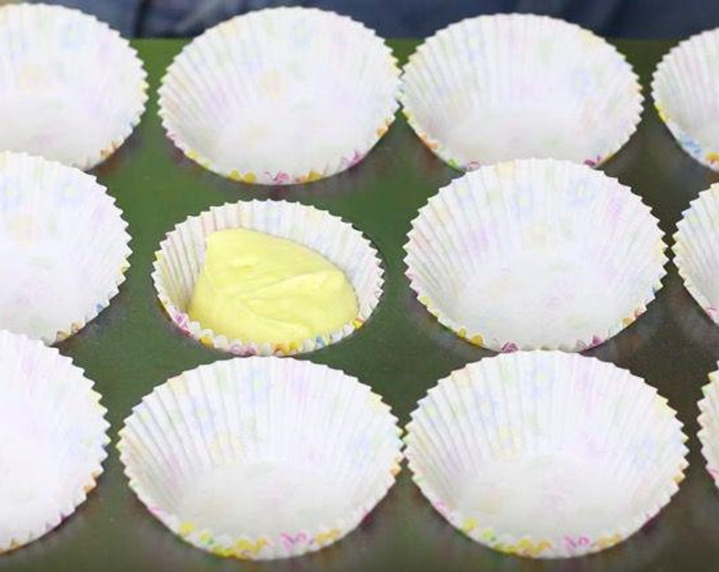 step 5 Line the cupcake tin with cupcake liners and add one scope of batter to each cupcake liner. Bake the cupcakes at 350 degrees F (180 degrees C) for 18 minutes. Cool them completely.